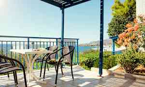 En terrass med stolar och ett bord, havsutsikt och grönska. (AI-genererad text)