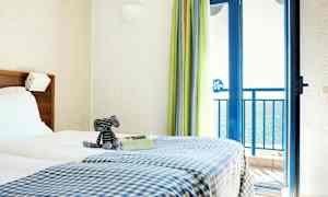 Rum med en dubbelsäng och havsutsikt. (AI-genererad text)