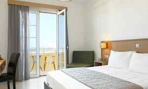Ett hotellrum med en dubbelsäng och en balkong med utsikt. (AI-genererad text)