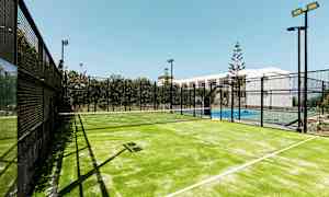 En upplyst padelbana utomhus med ett nät mellan spelplanerna. (AI-genererad text)