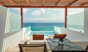 Utsikt över en terrass med två solstolar, ett bord och en privat pool, med havet i bakgrunden. (AI-genererad text)