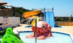 Färgglad vattenslide vid en badplats under klar himmel. (AI-genererad text)