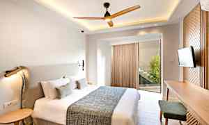 Ett modernt sovrum med en stor säng, ett skrivbord och en TV. (AI-genererad text)