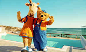 Två maskotar, en giraff och en björn, står vid en pool och vinkar. (AI-genererad text)