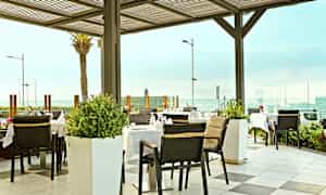 Utomhusrestaurang med havsutsikt. (AI-genererad text)