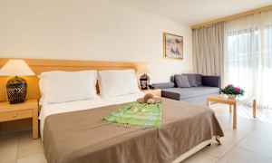 Hotellrum med dubbelsäng, soffa och bord. (AI-genererad text)