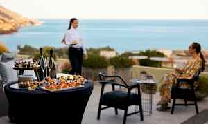 Bord med förrätt och drycker, i bakgrunden havsutsikt. (AI-genererad text)