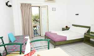 Ett hotellrum med en dubbelsäng, en soffa, ett bord med stolar och en balkong med utsikt. (AI-genererad text)