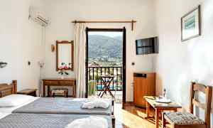 Hotellrum med två enkelsängar, spegel, TV och balkong med utsikt. (AI-genererad text)