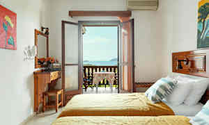 Ett hotellrum med två sängar och en möblerad balkong med utsikt över havet. (AI-genererad text)