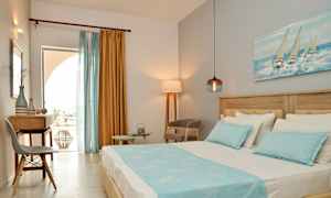 Vy av ett hotellrum med en säng, skrivbord och stolar, dekorerat med blå och gula färgtoner. (AI-genererad text)