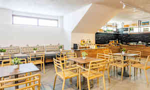 Ett modernt matsal med trästolar och bord samt dekorationer. (AI-genererad text)