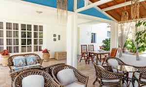 En luftig uteplats med sittmöbler av rotting och en dekorativ takdesign. (AI-genererad text)