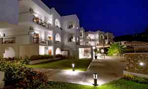 Vit byggnad med balkonger, upplyst om natten. (AI-genererad text)