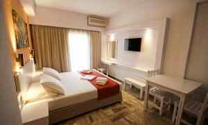 Ett hotellrum med en dubbelsäng, tv och sittmöbel. (AI-genererad text)