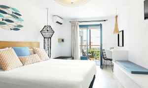 Ett modern inrett hotellrum med ljus inredning och en balkong. (AI-genererad text)