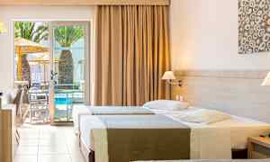 Hotellrum med tre sängar och en utgång till terrass med poolutsikt. (AI-genererad text)