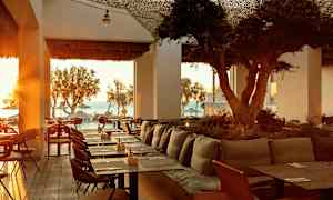 Restaurang med havsutsikt och solnedgång. (AI-genererad text)