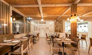 Interiör av en restaurang med dukade bord och stolar. (AI-genererad text)