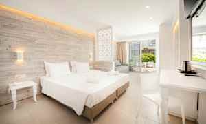 Modernt hotellrum med dubbelsäng, sittgrupp och balkong. (AI-genererad text)