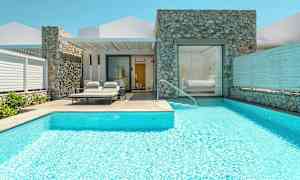 En villa med pool och solstolar vid ingången. (AI-genererad text)