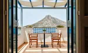 Vy från en terrass med två stolar och ett bord, mot ett berg i bakgrunden. (AI-genererad text)