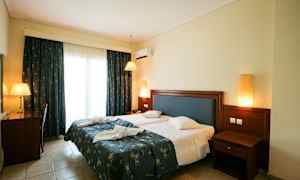 Bild av ett hotellrum med en dubbelsäng, skrivbord och nattduksbord. (AI-genererad text)