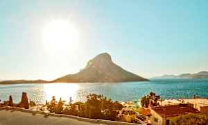 Solig kust med berg och hav i bakgrunden. (AI-genererad text)