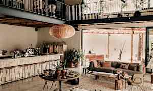 Interiör av ett modernt vardagsrum med öppen planlösning, inkl. sittmöbler och gröna växter. (AI-genererad text)