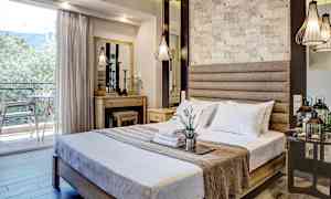 Ett hotellrum med en dubbelsäng, dekorativ belysning och en balkong med utsikt. (AI-genererad text)