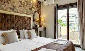 Hotellrum med dubbelsäng, skrivbord, spegel, och öppnande till balkong. (AI-genererad text)