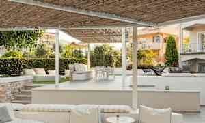 En terrass med sittplatser under pergola. (AI-genererad text)