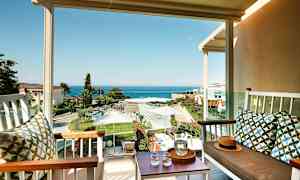 Vy från en terrass med sittmöbler mot en trädgård och havet. (AI-genererad text)