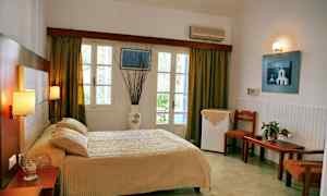 Hotellrum med säng, bord och stolar, fönster med gardiner. (AI-genererad text)