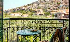 Utsikt från en balkong mot en sluttning med hus. (AI-genererad text)