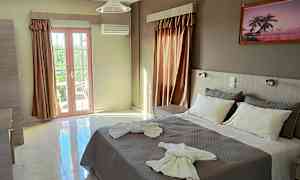 Ett hotellrum med en dubbelsäng, dekorerad med handdukar, och stora fönster som släpper in naturligt ljus. (AI-genererad text)