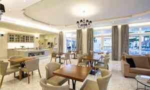 En modern matsal med ljus inredning, stolar och bord. (AI-genererad text)