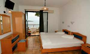 Ett hotellrum med två enkelsängar och en balkong med utsikt över havet. (AI-genererad text)