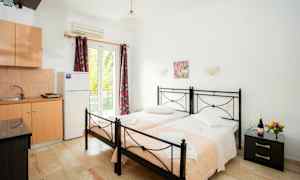 Två enkelsängar med rosa täcken i ett rum med köksutrustning. (AI-genererad text)