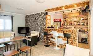 Ett vardagsrum med bar, sittmöbler och TV. (AI-genererad text)