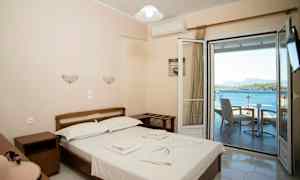 Dubbelrum med utsikt över havet genom en öppen balkongdörr. (AI-genererad text)