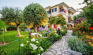 En välskött trädgård med ett hus i bakgrunden. (AI-genererad text)