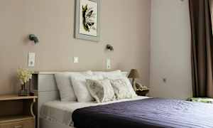 Ett sovrum med en säng, kuddar, och en mörklila sängöverkast. (AI-genererad text)