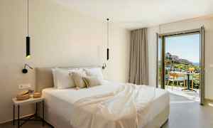 Modernt hotellrum med dubbelsäng och balkong som erbjuder utsikt över en pittoresk miljö. (AI-genererad text)