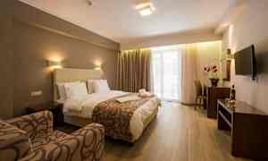 Ett hotellrum med säng, fåtölj, skrivbord och TV. (AI-genererad text)