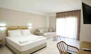 Ett hotellrum med en säng, soffa, skrivbord och stolar. (AI-genererad text)