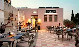 Uteservering vid restaurang med dukade bord och en musiker som spelar gitarr. (AI-genererad text)