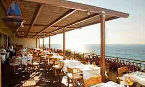 Restaurangterrass med dukade bord och havsutsikt. (AI-genererad text)