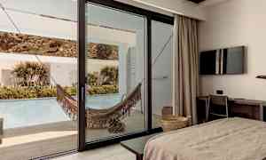 Hotellrum med utsikt mot terrass med hängmatta och pool. (AI-genererad text)