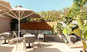 Utomhus sittområde med bord, stolar och växter. (AI-genererad text)